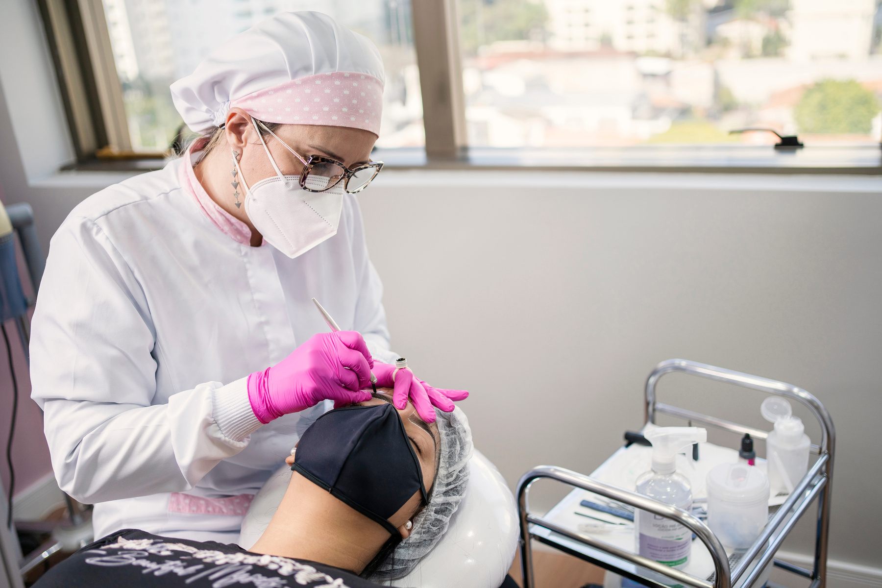 Beautician performing microblading technique in client eyebrow. Thread by thread micropigmentation